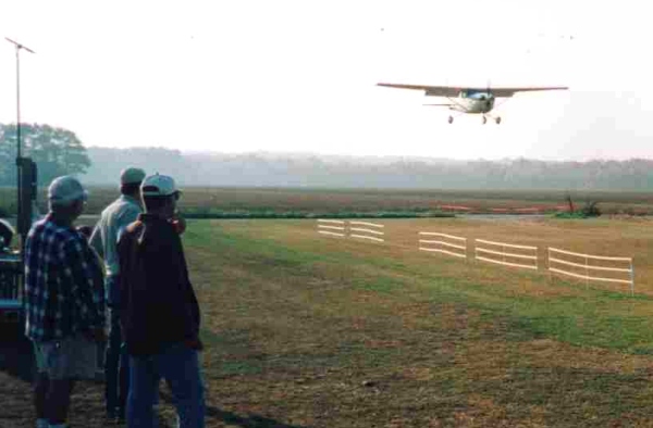 Studley pilots watch as an out of town visitor comes in on final